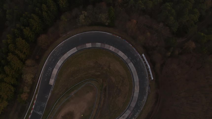 Numerous trees surround a racetrack