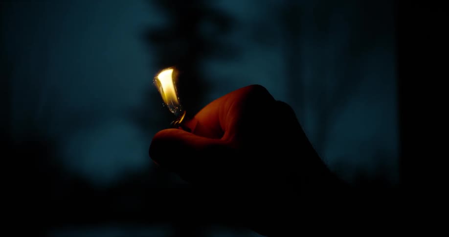 Someone lights a lighter outdoors