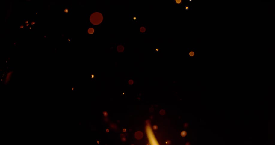 Fire embers float through the dark air