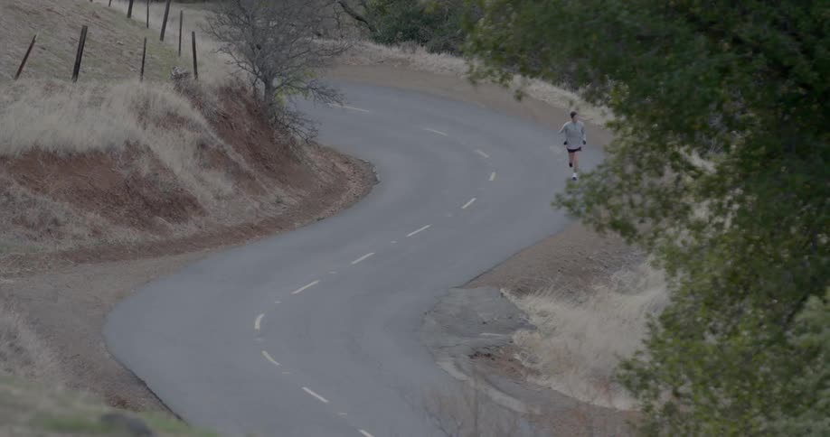 Man jogging on crooked street in the country