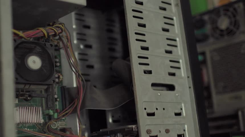 A fan spins in an open computer housing