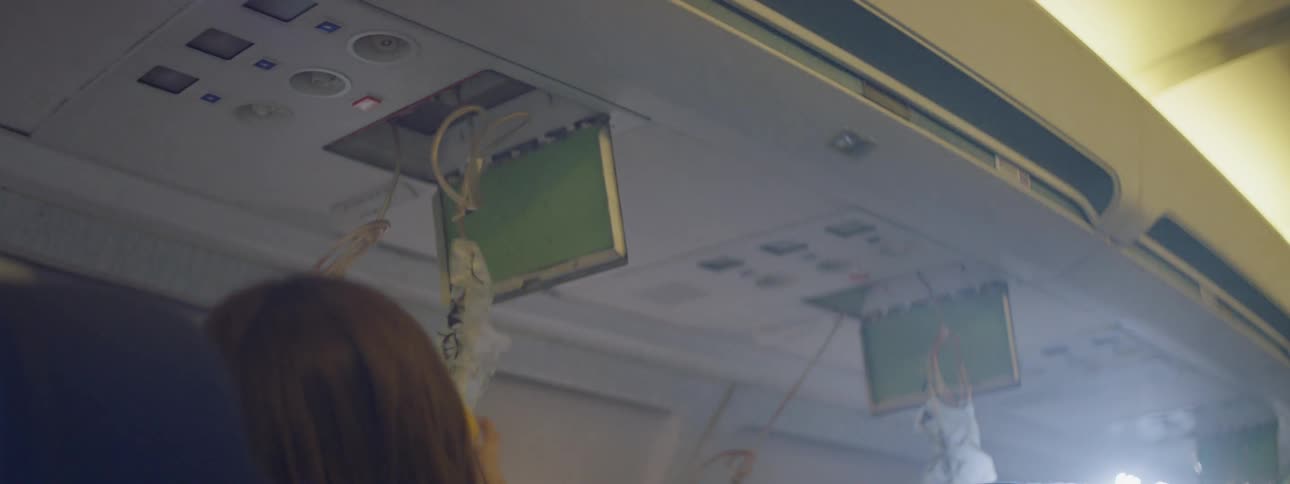 Oxygen bags drop from the ceiling of an airplane