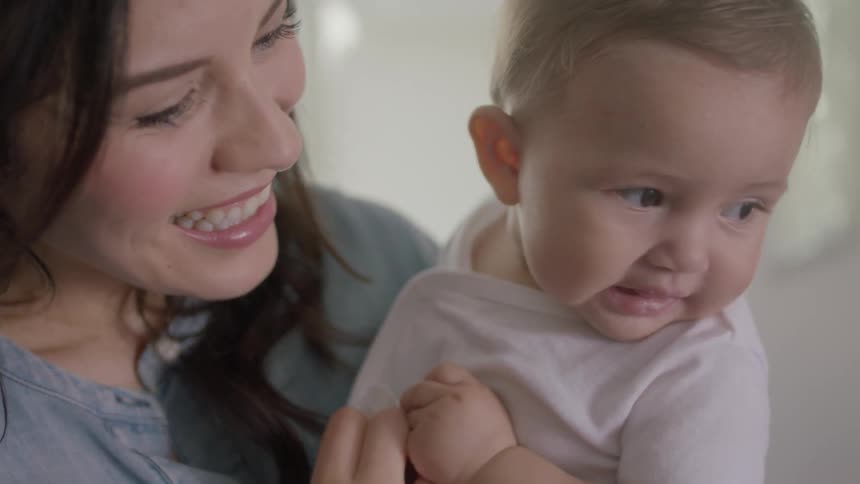 A woman is holding her child and laughing