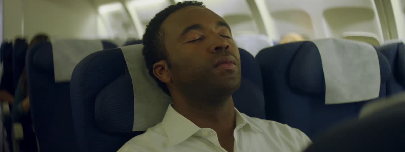 A man leans his head back on his seat