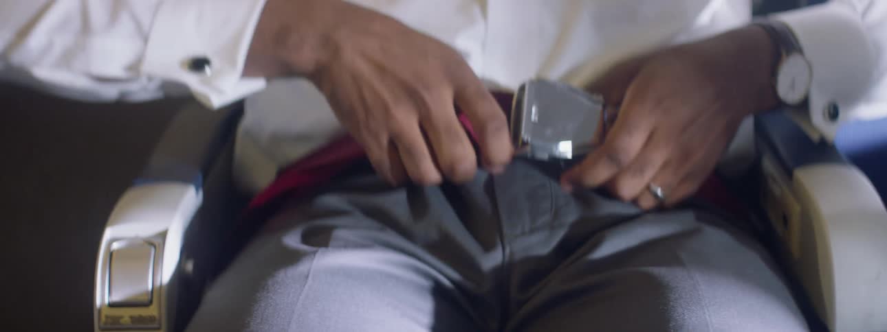 A man buckles his seatbelt and looks around nervously