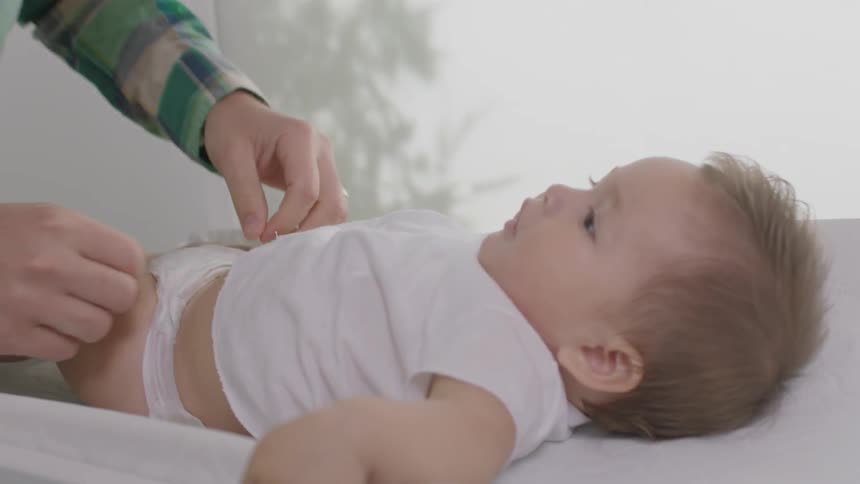 A man changes a baby's diaper