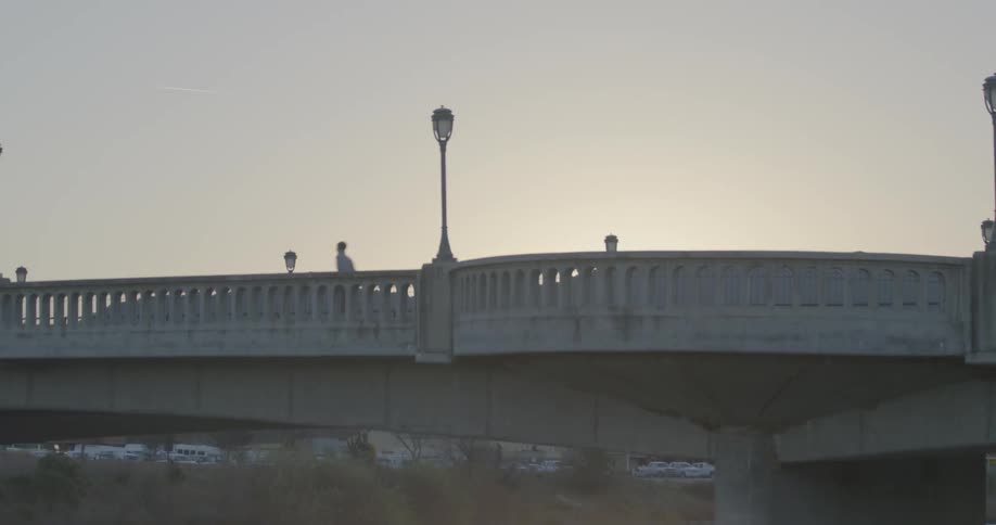 A bridge with joggers and light traffic in the early morning