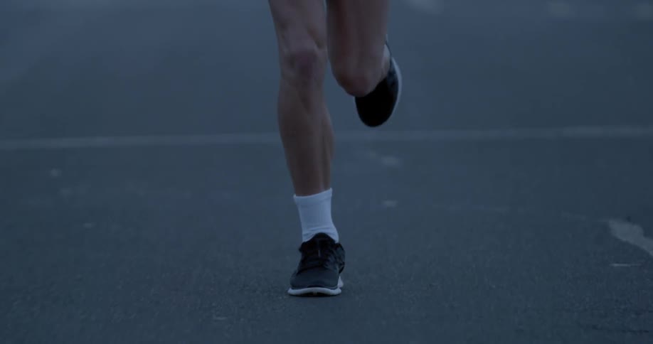 Man wearing sports shoes is jogging at dawn