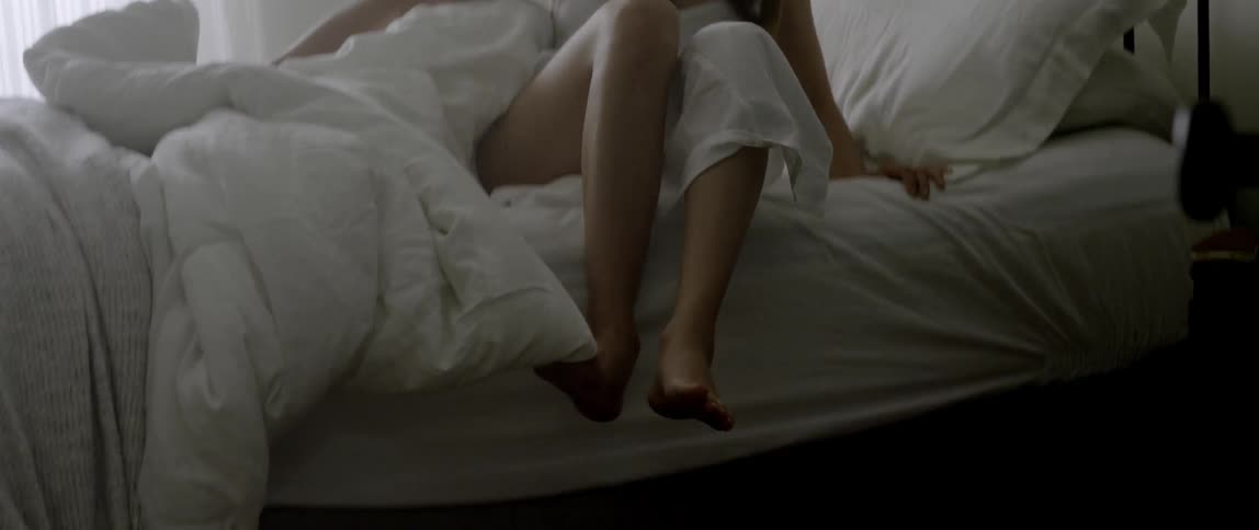 A woman just woke up and is getting out of bed