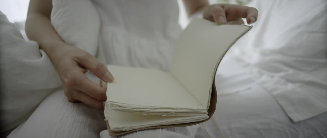 A woman is flipping through an empty notebook