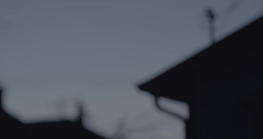 Tops of houses shown at dusk
