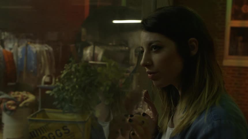 A woman is standing with her face pressed against a glass window