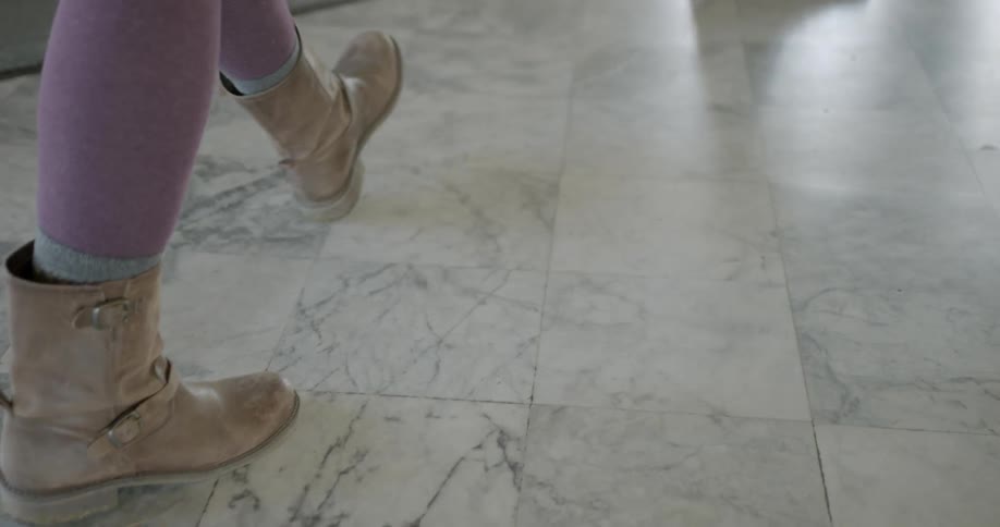 Two people walk on the tiled floor