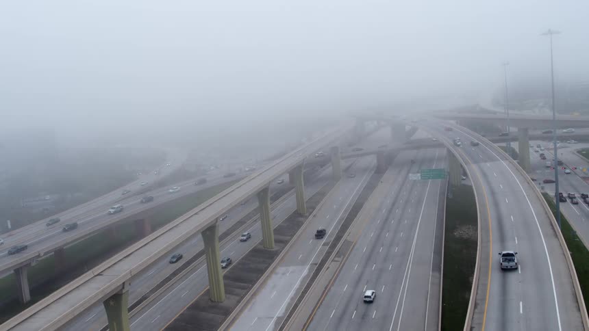 Fog hovers over a freeway complex