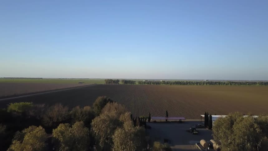 Farm fields stretch out around a farm compound
