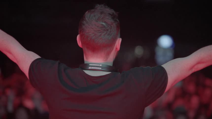 A dj is interacting and dancing with the crowd during a performance