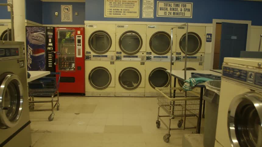 Washers dryers and vending machines sit in a laundromat