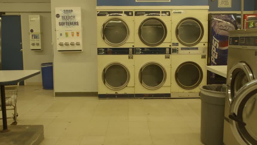 Machines in a laundromat line the wall