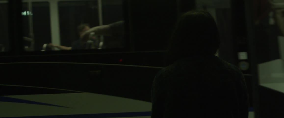 A woman waits for a passenger train to arrive