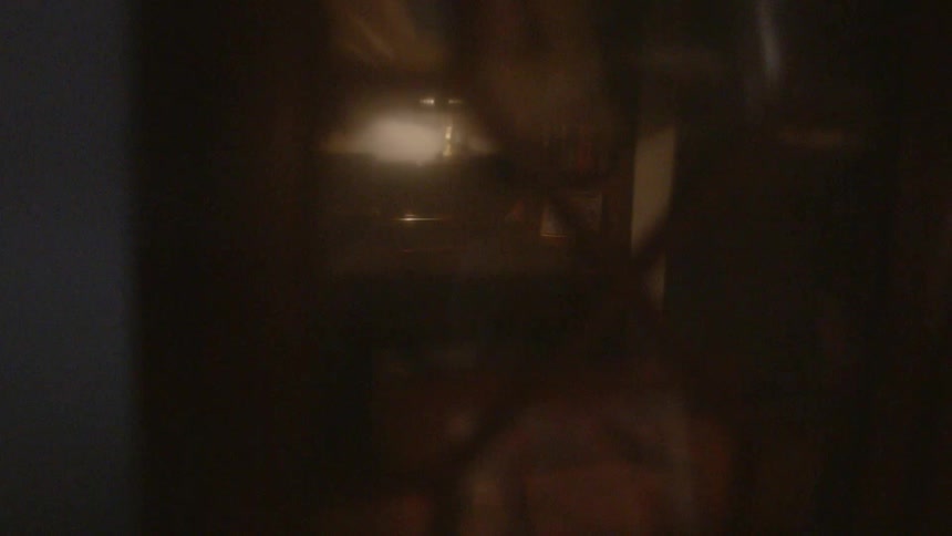 A child walking in a room is reflected on a cabinet glass door