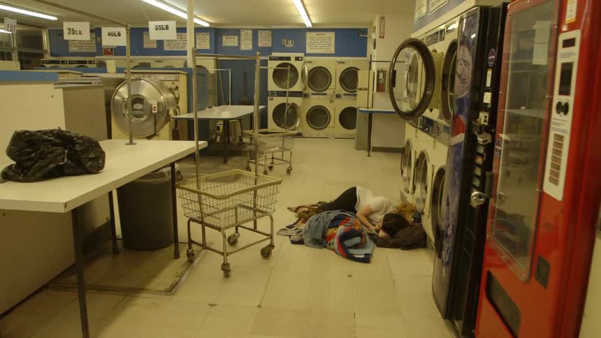 Person sleeps on a laundromat floor