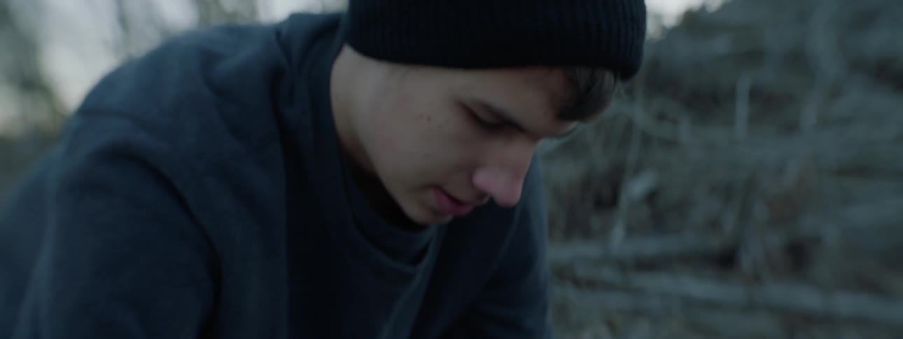 A man wearing a beanie digs into the ground