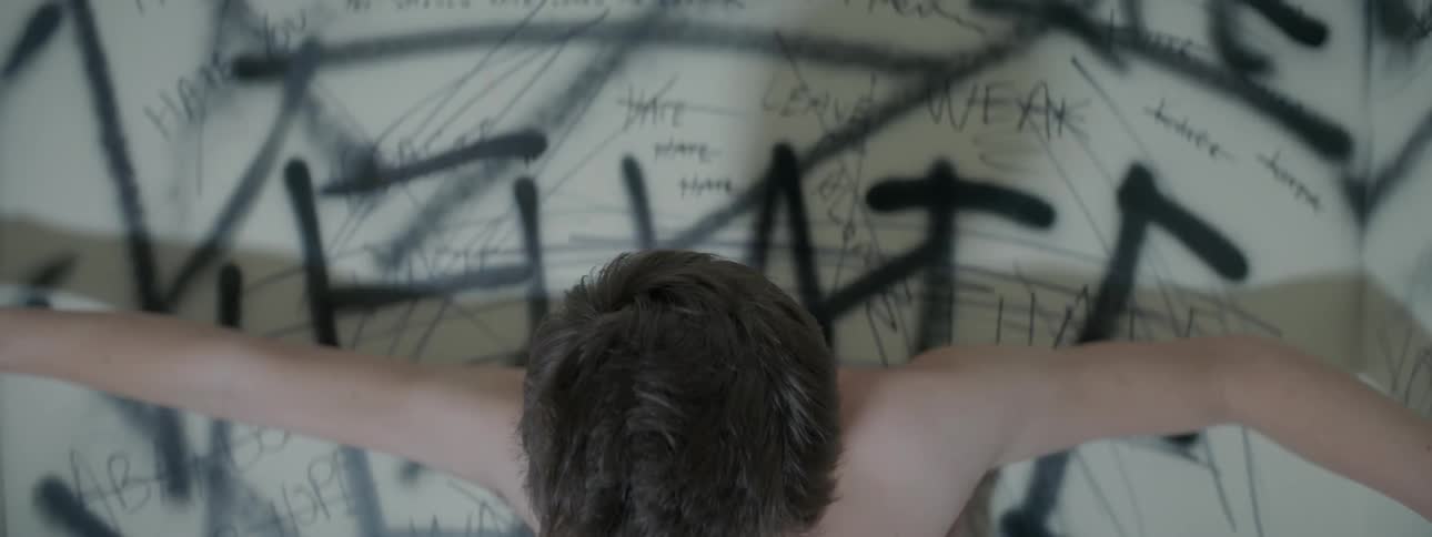 Lights flash on a man stretching in a spray painted room