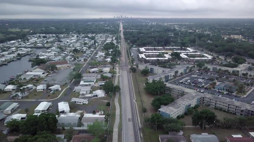 Clouds hover over a community on the outskirts of a large city