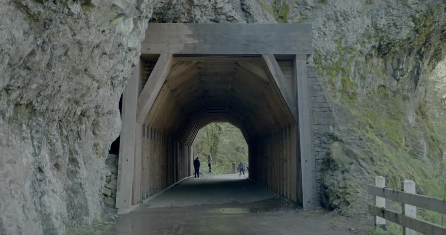 People standing at the other end of the narrow tunnel