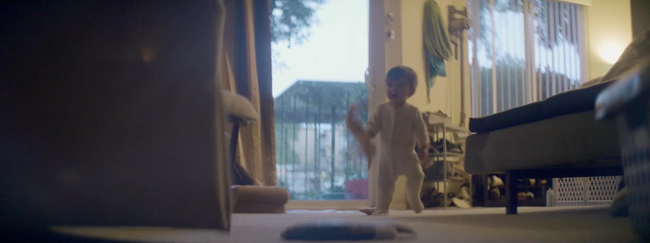 A toddler walks around holding a stuffed bunny