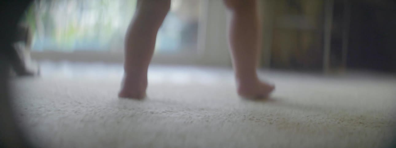 A baby takes some steps on the carpet