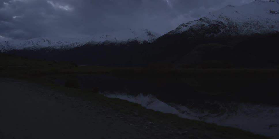 A snow covered mountain on a cloudy evening