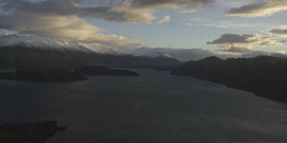 A lake flows between two mountains while the sun rises
