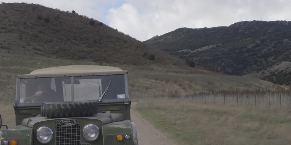 A jeep driving past mountains