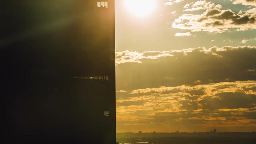 Time lapse of the sun coming out from behind a building