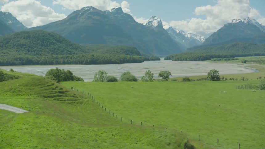 A field leads rolling mountains