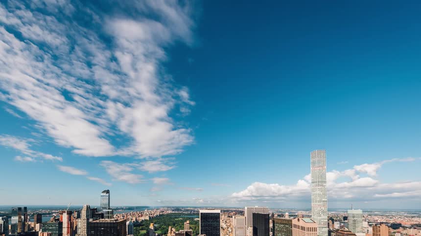 A few clouds soaring over a large city