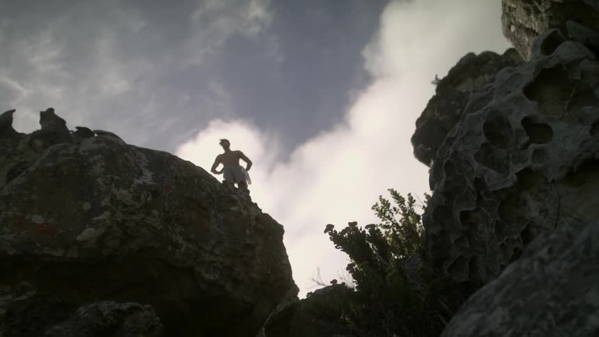 A man stands on the cliff above