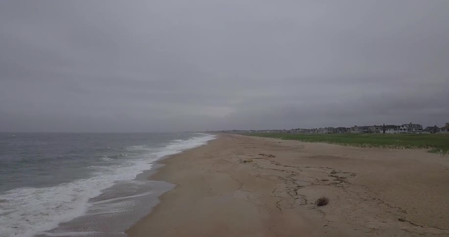 Ocean waves wash ashore a sandy beach