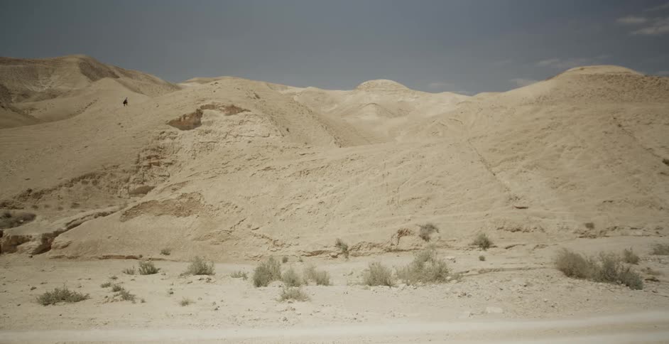 View of the desert and a person walking up a hill