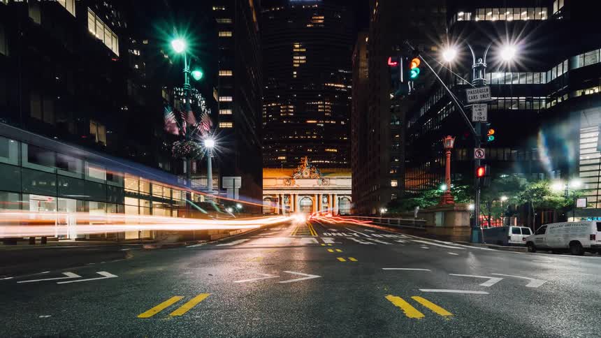Vehicles travel over a city street during the night
