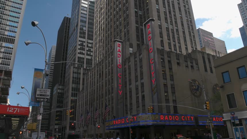 Radio city building signs illuminate on the street