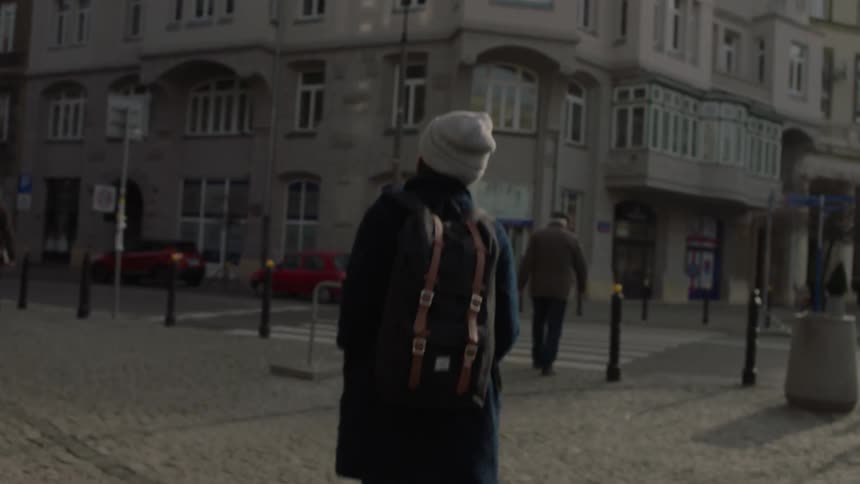 A woman walks down a city sidewalk