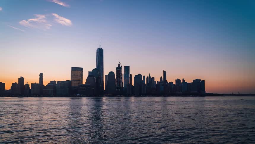 The city over the water is brightly lit at night