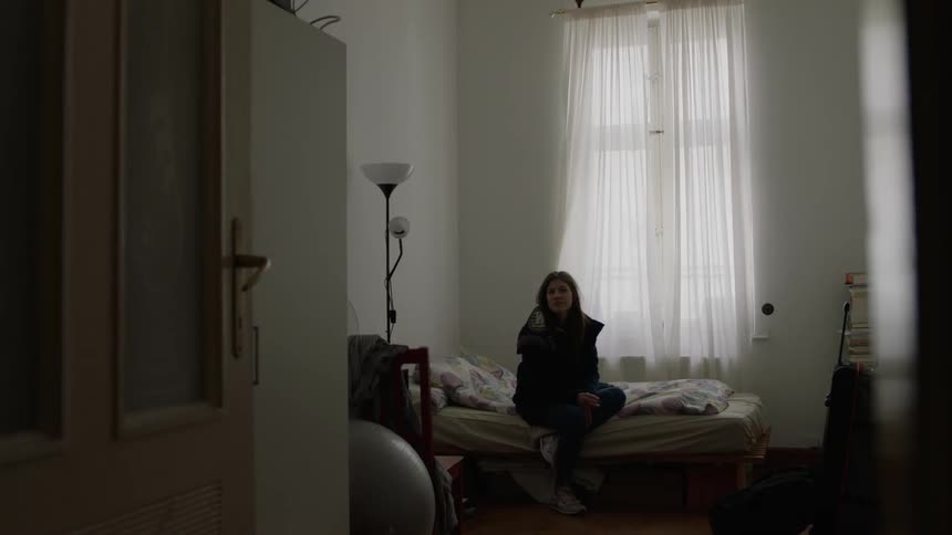 A woman sits on a bed