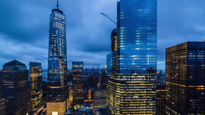 Illuminated buildings stand tall under a cloudy sky