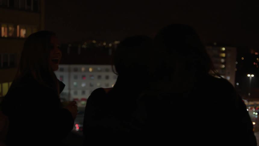 A group of women stand atop a rooftop