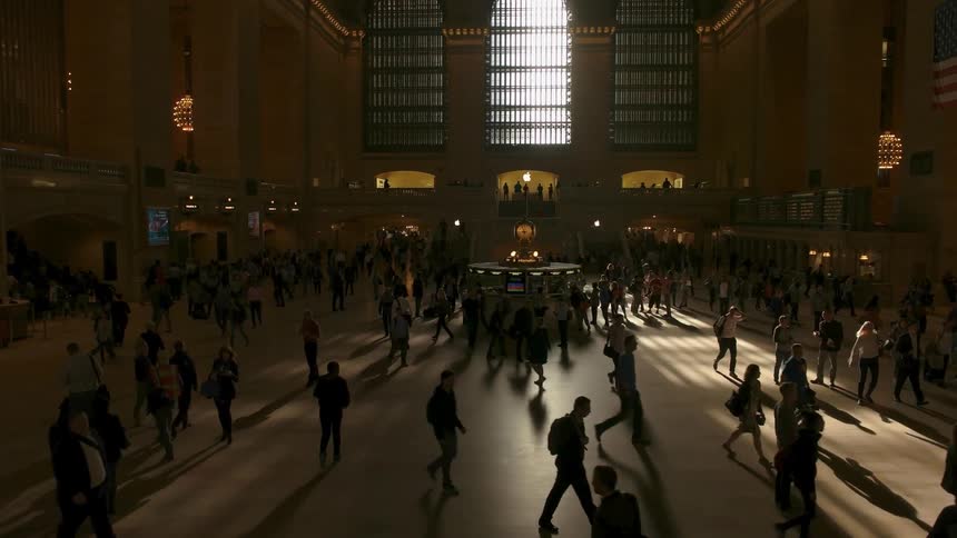 A bunch of people are walking inside a large building