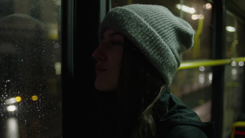Person riding a bus looking out a window
