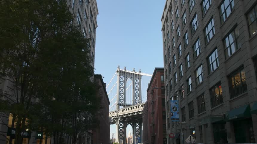 The manhattan bridge is being filmed from a street